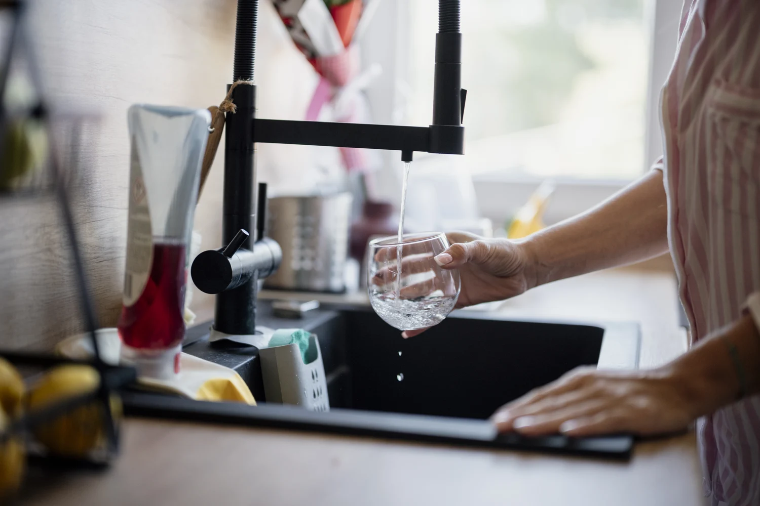 Eau coulant d’un robinet de cuisine dans un verre